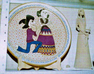 A Catrín goes down on his hands and knees to beg forgiveness from his love, depicted on a plate created at Alfarería de San Francisco in Capula.