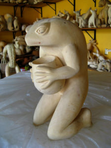 A kneeling anthropomorphic figure holds a jar. Oaxaca artisan Jacobo Angeles creates the unique wood carving. © Alvin Starkman 2008
