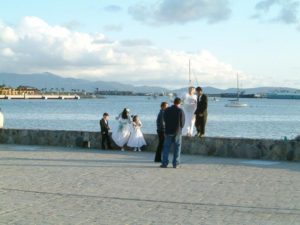 A newly married couple pose in the Plaza Ventana al Mar with the harbor in the background.