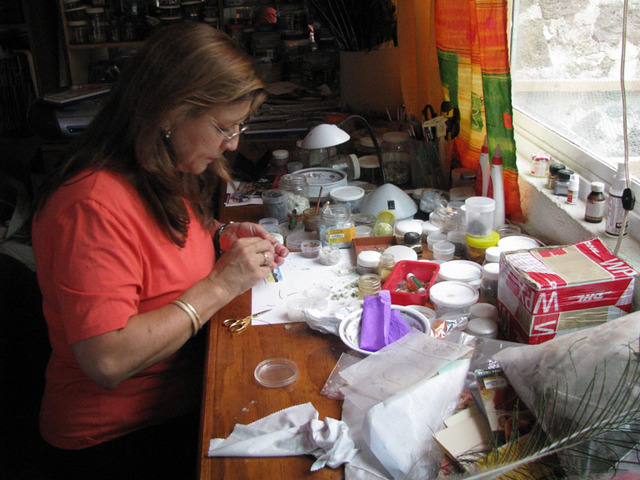 Jars and bags full of feathers clutter Martha's desk. A dizzying array of colors -- pale green and cerulean blue and chocolate and raw umber -- clamor for attention.