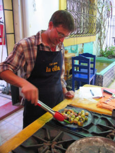 Toasting tomatillos and chile serrano on a comal. These traditional Mexican techniques are used for the salsa. © Alvin Starkman 2008