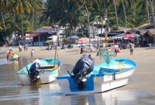 Shallow waves lap at snall boats with outboard motors on the beach at Los Ayala on the Pacific coast of Mexico. © Christina Stobbs, 2009