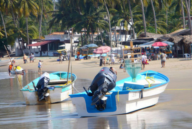 Shallow waves lap at snall boats with outboard motors on the beach at Los Ayala on the Pacific coast of Mexico. © Christina Stobbs, 2009