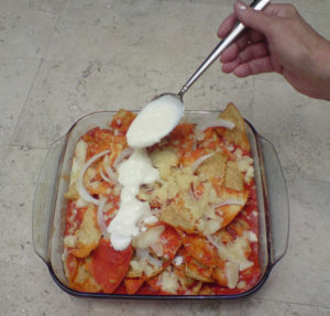 Jocoque, a thick yogurt, is spooned over the hot chilaquiles. Thick cream or sour cream can also be used, depending on your preferences. © Daniel Wheeler, 2009