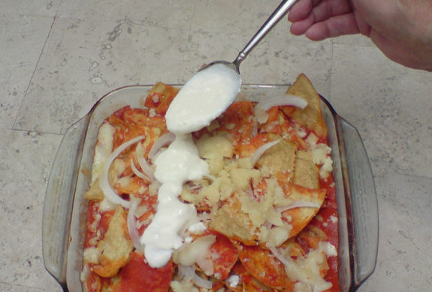 Jocoque, a thick yogurt, is spooned over the hot chilaquiles. Thick cream or sour cream can also be used, depending on your preferences. © Daniel Wheeler, 2009