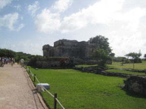 Tourists explore ancient Maya ruins in Tulum and admire the beauty of the past.