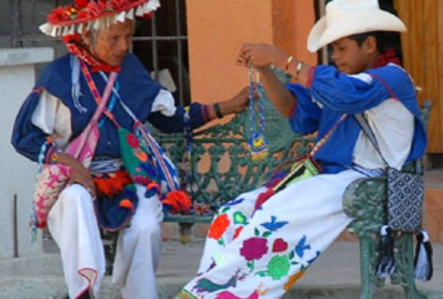 “You see, my boy,” grandpa says, “this is the way it is done.” A Huichol man and boy in traditional dress on a Melaque street. © Gerry Soroka, 2009