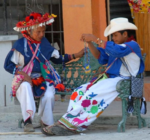 “You see, my boy,” grandpa says, “this is the way it is done.” A Huichol man and boy in traditional dress on a Melaque street. © Gerry Soroka, 2009