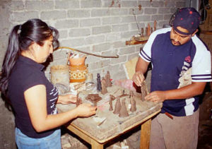 María de los Angeles and her husband Francisco Barocio Jacobo work on some small hand-sized Catrinas in their workshop.