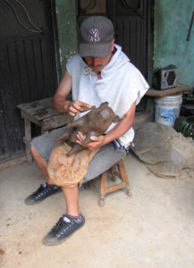 Leonardo, the son of José María and Cecilia, prepares a fresh clay pig for its share of new decorations.