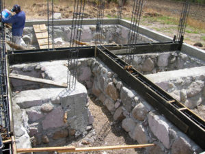 The big boulder foundation rocks are rolled into place, the cement mixed, the rebar wall uprights secured. © Norma Hawthorne 2008
