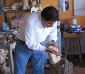 Jacobo Angeles extends a hand to show one of the paints used in his wood carvings. The Oaxaca artisan is a master of Mexican folk art. © Alvin Starkman 2008