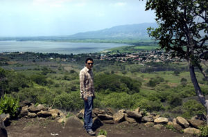 Archeologist Rodrigo Esparza, co-director of the Teuchitlan Project, with the Guachimontones pyramids, the town of Teuchitlan and Lake La Vega in the background. The Ocomo Palace is located 35 kilometers to the west of these sites. © John Pint, 2009