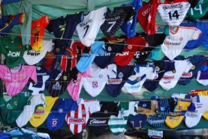 A stall displays three walls of sports jerseys at the Tuesday Market in San Miguel de Allende, Mexico © John Scherber, 2013