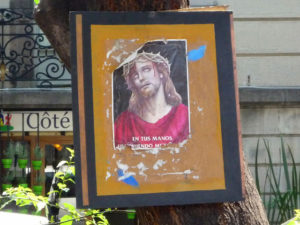 Jesus grimly holds on in a tattered religious poster attached to a tree in Mexico City. © Anthony Wright, 2011