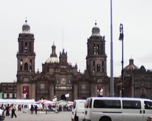 The Zocalo in Mexico City with traffic, protesters and the emblematic Metropolitan Cathedral in the background © Lilia Wall, 2014