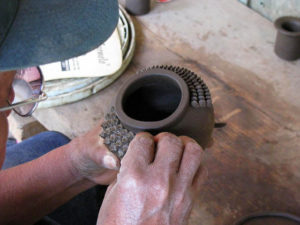 José María Alejos Madrigal places pellizcos (pinches) of clay on one side of a pot, giving it the distinctive look of pineapple pottery. Pico fino dots the other side.