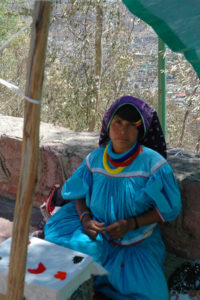At the top of La Bufa the road is lined with women and their children, all garbed in the brightly colored traditional clothes of the Huichol, an indigenous group of people with their own customs and language.
