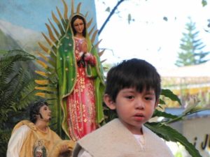 Young Oaxacan boy dressed as 'indito', with the virgin and Juan Diego behind him © Tara Lowry, 2014