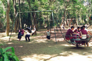 Children can frolic on the swings and slides in this playground in the park.