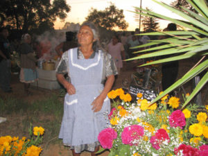 This woman knew I was taking her photo, so she posed proudly next to flowers that will decorate the family plot.