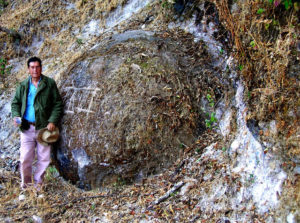 Roberto "Beto" López Santiago of Etzatlán poses alongside a half-buried megaspherulite lying alongside the road to the old Amparo silver mine, 4.7 kilometers north of the Piedras Bola developed area in Jalisco. © John Pint, 2009