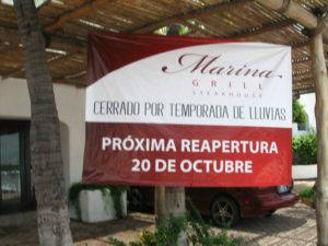 A "closed" restaurant at the Las Hadas marina announcing it's reopening in October (although blaming the closure on rain) sums up Manzanillo, Mexico, which has its high season in the winter. © Donald MacKay, 2011