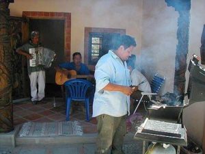 Carne Asada, thinly sliced beef is being prepared on the grill by one of the workers. The gilled meat will be served with beans, guacamole, Salsa Mexicana, very, very hot chile sauce and mounds of tortillas and plenty of cold beer.