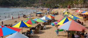 Colorful umbrellas shade beach chairs along the shore in Melaque, a small Mexico beach town. © Gerry Soroka, 2009