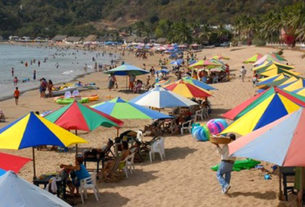 Colorful umbrellas shade beach chairs along the shore in Melaque, a small Mexico beach town. © Gerry Soroka, 2009