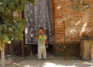 A tyke takes a sip of Sprite in front of his no-frills Melaque home. © Gerry Soroka, 2009