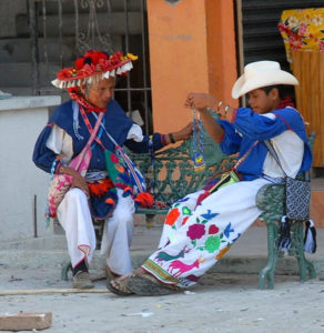 “You see, my boy,” grandpa says, “this is the way it is done.” A Huichol man and boy in traditional dress on a Melaque street in Mexico. © Gerry Soroka, 2009
