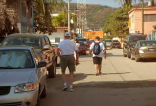 Tourists straddle a Melaque street road, inviting a host of curses and, maybe, of injuries. © Gerry Soroka, 2009