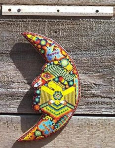 A yellow eagle stretches her wings across the crescent moon where blue deer frolic. Celestial images figure prominently in Huichol art motifs. This beaded moon comes from the collection of Robert Otey. © Robert Otey, 1997