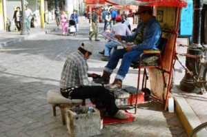A man shines shoes on Plaza Manuel Acuña.