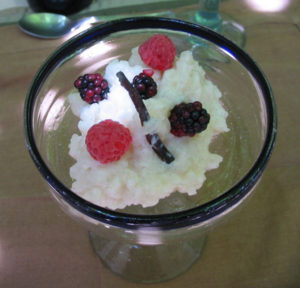 For dessert -- arroz con leche (Mexican rice pudding) speared with a length of wild vanilla bean and crowned with fresh berries. © Alvin Starkman 2008