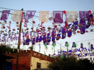 Banners of 'papel picado,' or tissue paper cutouts, stretch across the street where the Easter procession will go by. The Procession of Our Lord of the Column takes place each year on Good Friday in San Miguel de Allende. © Edythe Anstey Hanen, 2013