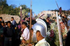 Spectators line the streets of San Miguel de Allende in Mexico in the 1960s. Dressed as Roman centurians, townspeople parade through town, accompanying a procession of beloved religious images. They stage a passion play each year on Good Friday. © Don Fyfe Wilson, 1964, 2010
