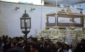 After the midday Passion Play and an afternoon of silence, religious images are carried through the town, with the body of the crucified Jesus in a glass coffin on a funeral bier. Crowds of silent mourners, dressed in black, accompany the statues with measured drumbeats marking the compass. These processions are part of the annual Good Friday observances in the Mexico town of San Miguel de Allende. © Don Fyfe Wilson, 1964, 2010