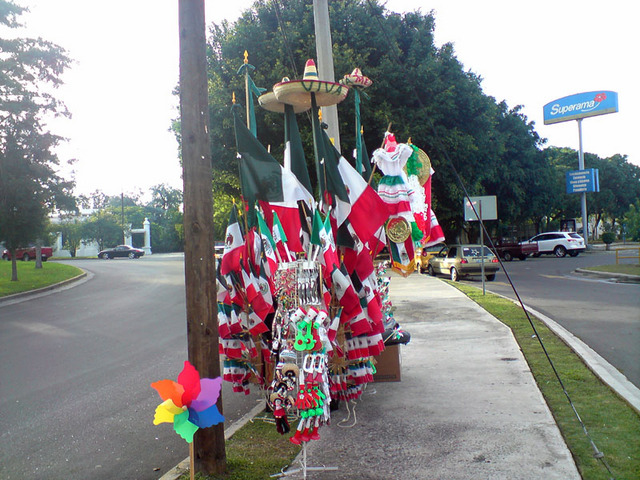 In September, Mexico's most patrotic month, itinerant merchants offer Mexican flags in all sizes. This enterprising merchant sets up shop outside a supermarket. © Daniel Wheeler, 2009