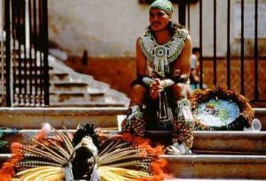 A resting Conchero Dancer watches his fellow dancers. Men and women play equal roles in the organization of these dance troups, unusual in Latin America.
