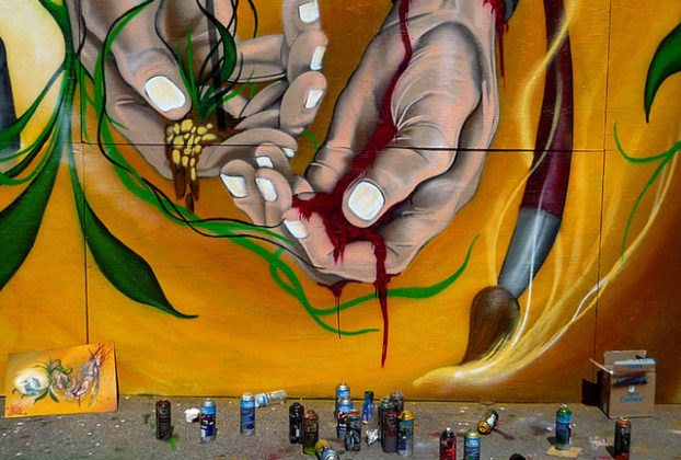 The graffiti artist's tools of the trade-spray paint cans-lie at the base of a dramatic impression by a wall artist in Mexico City. © Anthony Wright, 2009