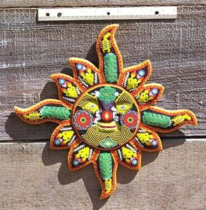 Green corn plants cool the sun's fiery rays, while golden deer heads alternate. This dazzling beaded Huichol mask depicts the sun. It comes from the extensive Huichol art collection of Robert Otey