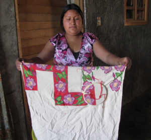 Elena Reyes Ascencio is working to decorate this guanengo blouse (displayed by her granddaughter) with needlepoint. The 84-year-old native of Cocucho, Michoacan, is a needlework artist. © Travis Whitehead, 2009