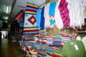 Colorful sarapes, ponchos and other garments line the aisles of Mercado Juárez.