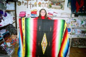 Leonor Valencia, general manager of one of the many shops in Mercado Juárez, holds up one of the sarapes she sells in her store. This one, made of acrylic and wool, is worth 750 pesos, about $75.