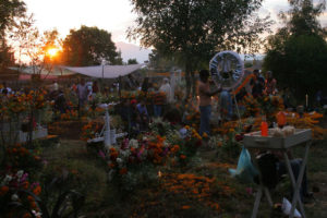 As the sun sets, the panteón is transformed. Candles are lit and families settle down to spend the night in front of their loved ones' tombstones.