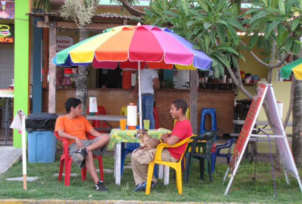 Waiting for Los Abuelos restuarant to open, its waiters befriend the dog. The restaurant in Tecolutla, Mexico, is a 1950s-style hamburger hut. © William B. Kaliher, 2010