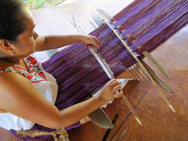 Intricate geometric motifs come to life on a warp of red, black and purple as a skilled weaver works on the backstrap loom. She is a member of the Tixinda women's cooperative in Pinotepa de Don Luis, Oaxaca. © Geri Anderson, 2011