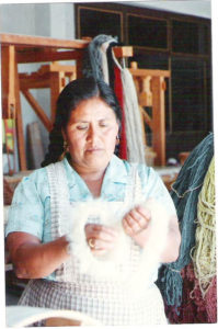 Gloria de Santiago cards wool in their Oaxaca workshop for a handwoven Zapotec rug. © Alvin Starkman, 2007